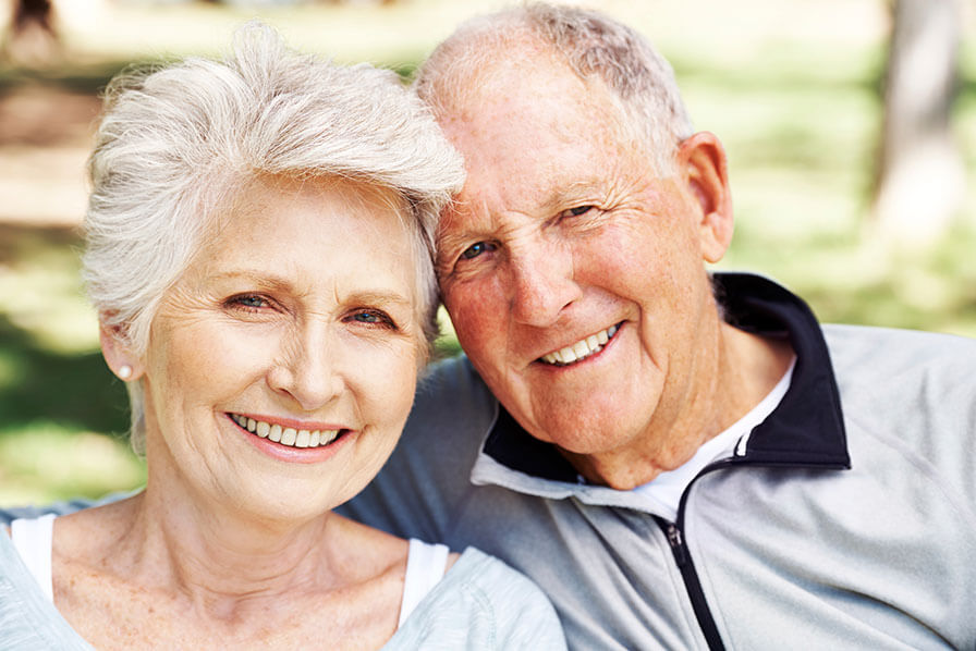 An elderly couple smiling at the camera 
