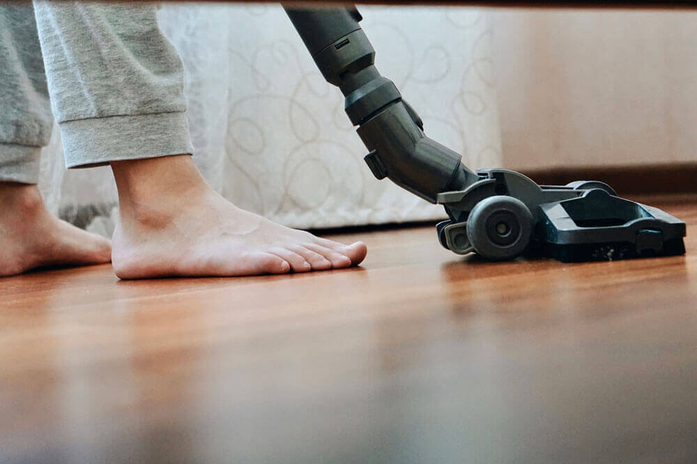 A person vacuums their home