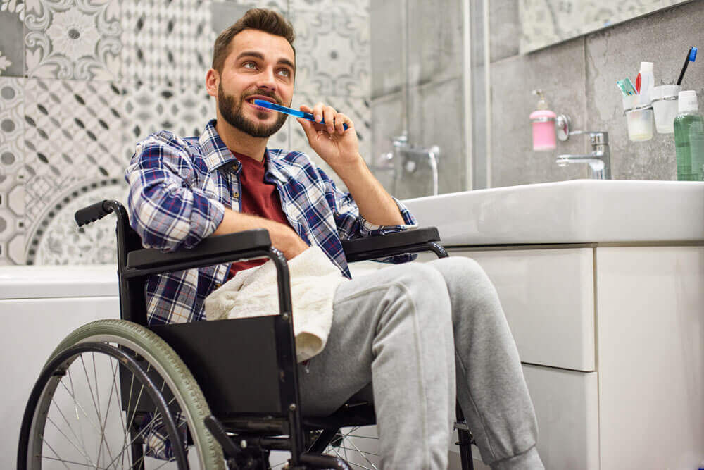 personal-care a man in a wheelchair brushes his teeth