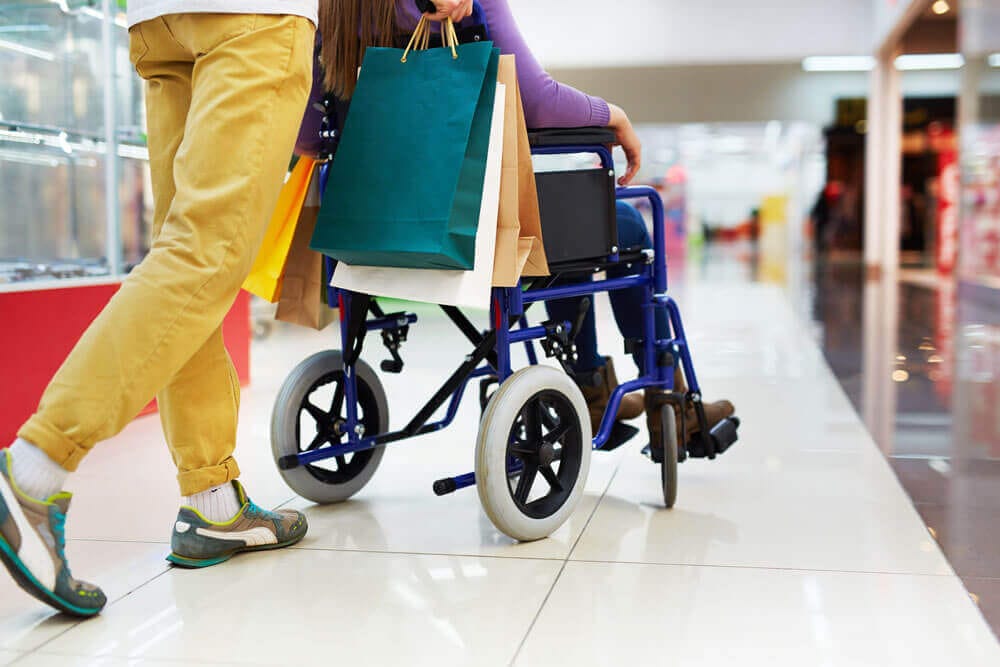 A woman in a wheelchair receives shopping assistance 