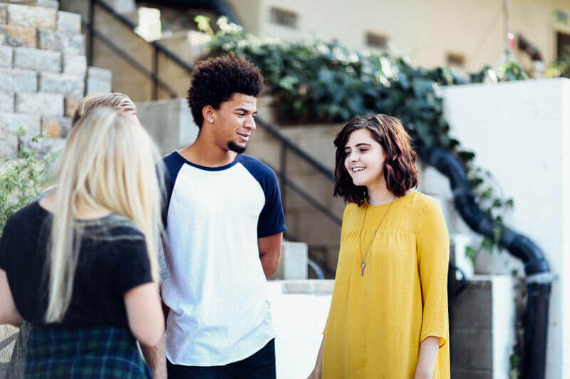 young carers standing in a group talking to each other